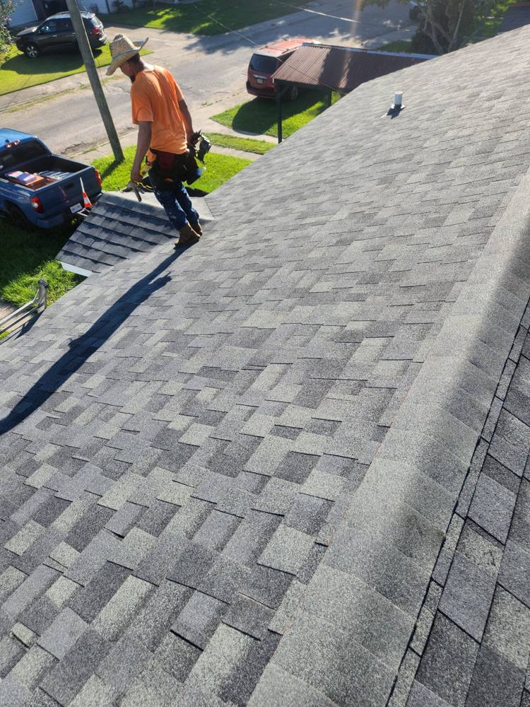 Roofer inspecting a shingle roof
