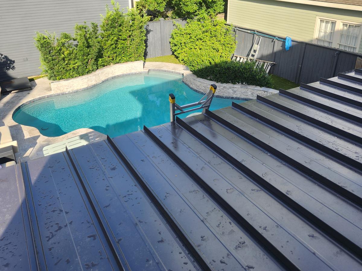 Standing seam metal roof above a backyard pool