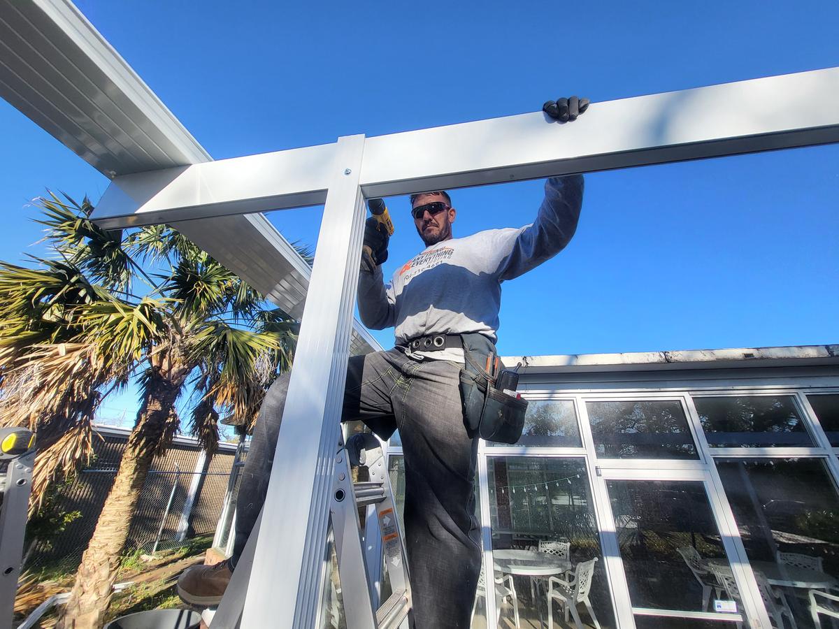 Crew member assembling an aluminum patio cover frame