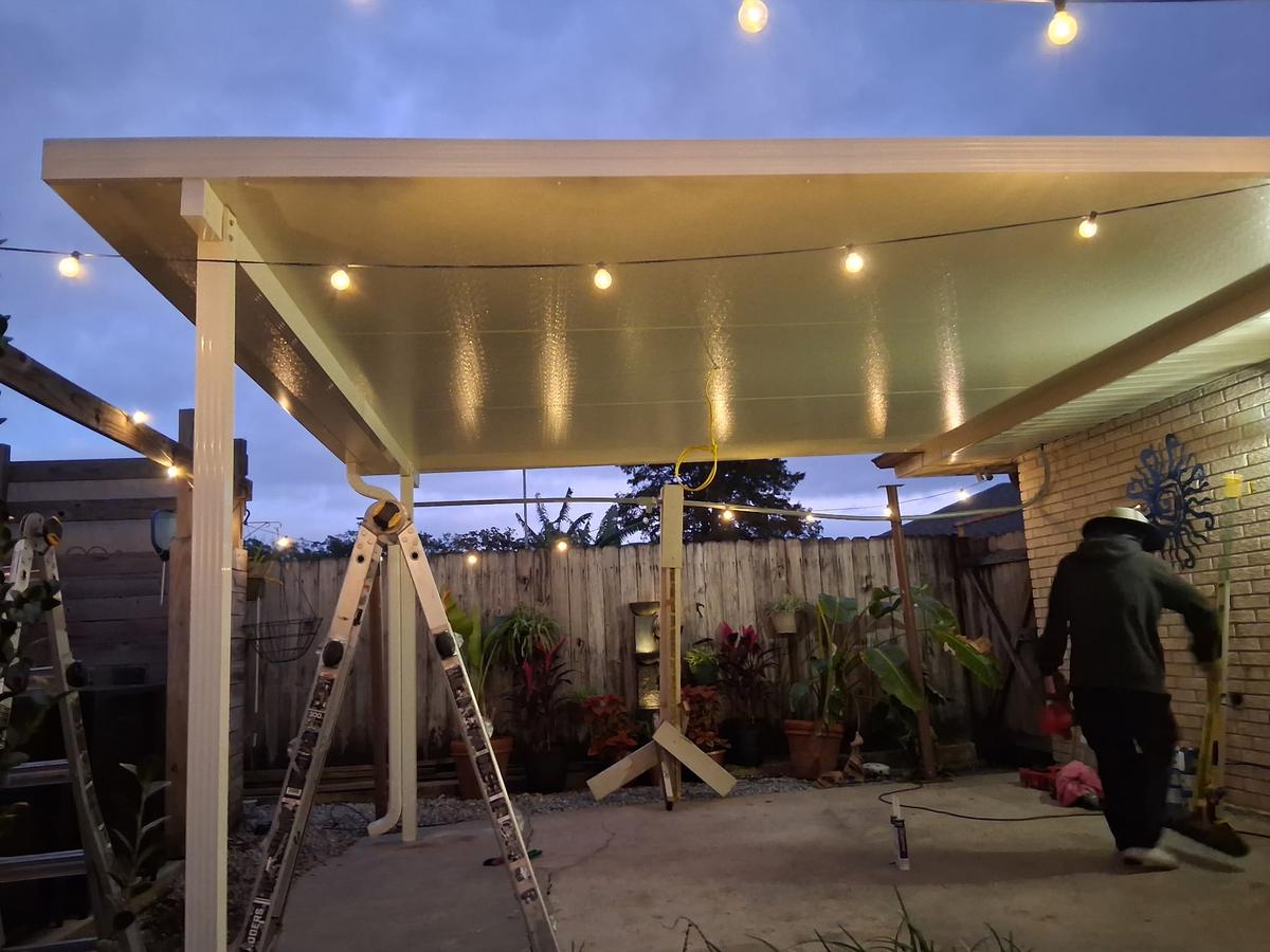 Insulated patio cover lit with string lights at dusk